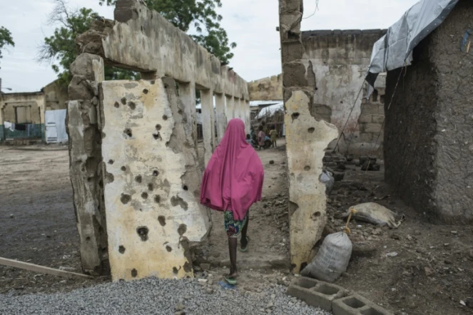 Une fille marche sur un site bombardé à Rann près de la frontière camerounaise le 29 juillet 2017