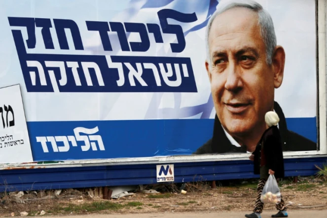 Une arabe israélienne marche devant une affiche électorale montrant le Premier ministre israélien Benjamin Netanyahu, à Haïfa (nord), le 4 avril 2019