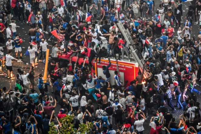 Un camion de pompiers pris d'assaut par des supporters en liesse après le succès de la France en finale du Mondial, le 15 juillet 2018 sur les Champs-Elysées 
