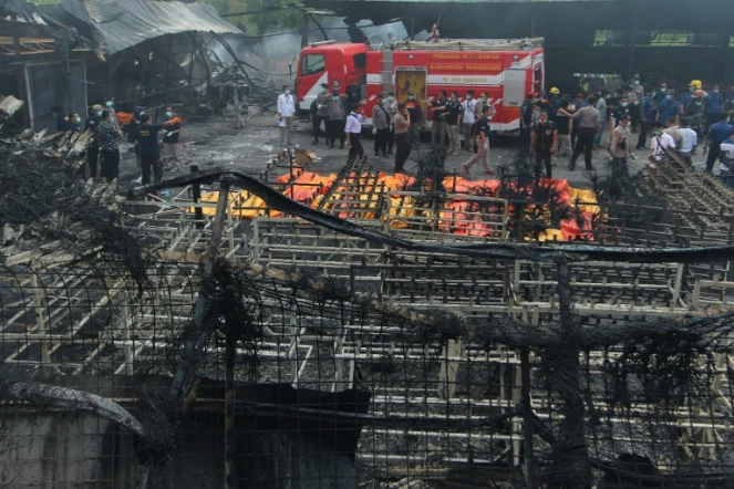 Policiers et équipes de secours sur les lieux d'un incendie qui a ravagé une usine de feux d'artifice, le 26 octobre 2017 à Tangerang Kota, en Indonésie
