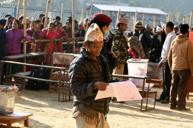 Un Népalais examine les bulletins avant de voter, le 26 novembre 2017, à Chautara, dans le district de Sindhupalchowk