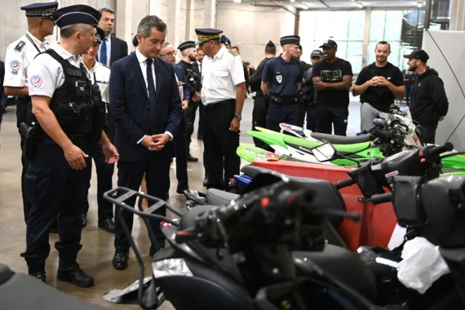 Le ministre de l'Intérieur français (4e à g) devant des deux-roues saisis par la police après des rodéos urbains à l'hôtel de police de Créteil, le 17 août 2022