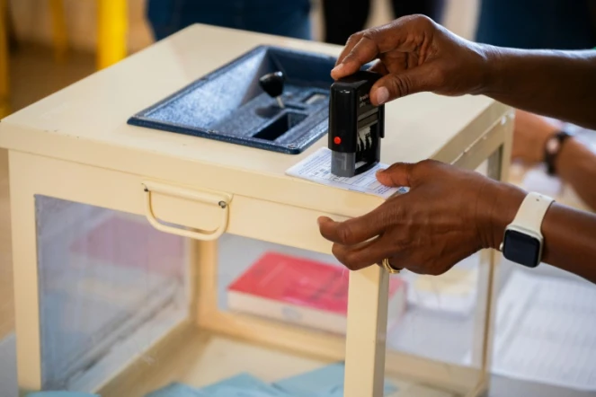 Un assesseur tamponne une carte électorale dans un bureau de vote au premier tour des législatives à Sainte Rose, en Guadeloupe, le 29 juin 2024