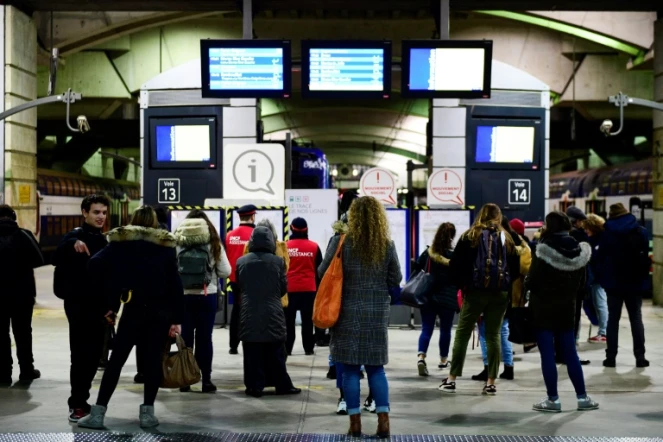 Des voyageurs consultent les panneaux d'informations sur le trafic des trains, à la gare Montparnasse à Paris, le 7 janvier 2020