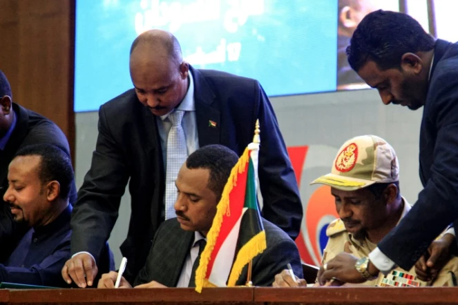 Le meneur de la contestation Ahmed al-Rabie (C), et le général Mohammed Hamdan Daglo (D), numéro deux du Conseil militaire soudanais, signent un accord de transition, à Khartoum, le 17 août 2019