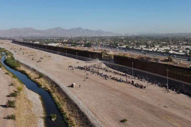 Des migrants attendent d'être pris en charge par la police aux frontières américaine près des rives du Rio Grande à Ciudad Juarez, au Mexique