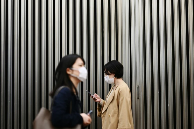 Deux femmes portent un masque de protection pendant l'épidémie de coronavirus, le 18 mars 2020 à Tokyo, au Japon