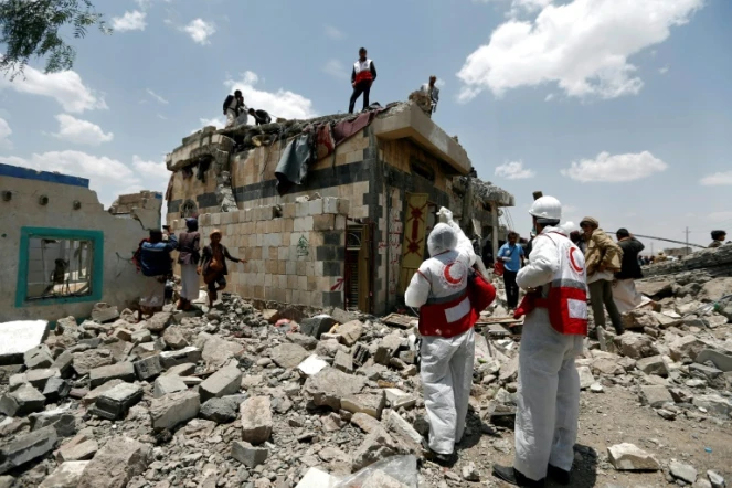 Des employés du Croissant Rouge du Yémen et des civils à Arhab, localité située à la sortie nord de Sanaa, sur le site frappé par un raid aérien, le 23 août 2017