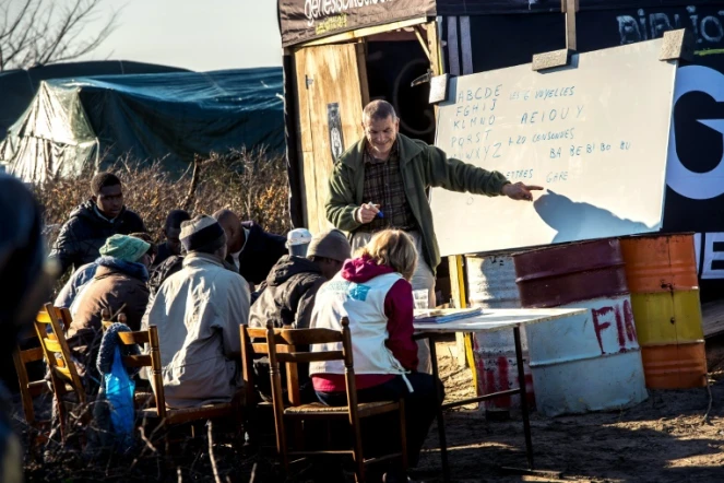 Un bénévole fait la classe à des enfants migrants dans le camp de la "Jungle" à Calais, le 16 février 2016