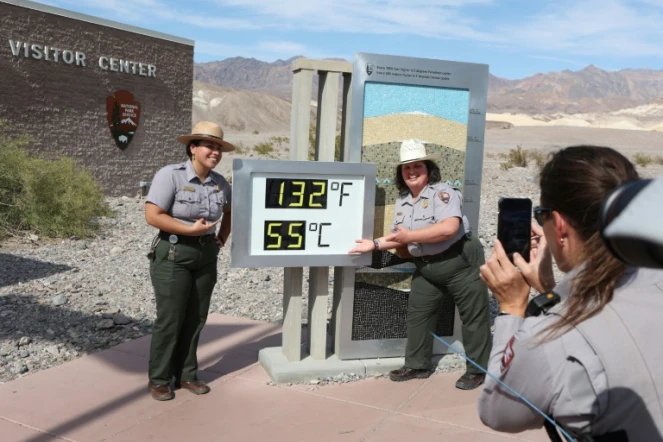 Des rangers posent autour d'un thermomètre indiquant 55°C, dans la Vallée de la mort, en Californie, le 16 juin 2023