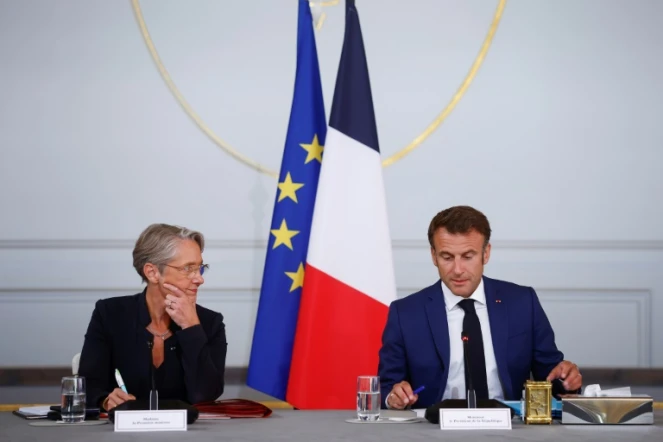 La Première ministre Elisabeth Borne (G) écoute le président Emmanuel Macron (D) au palais de l'Elysée à Paris le 19 juillet 2023