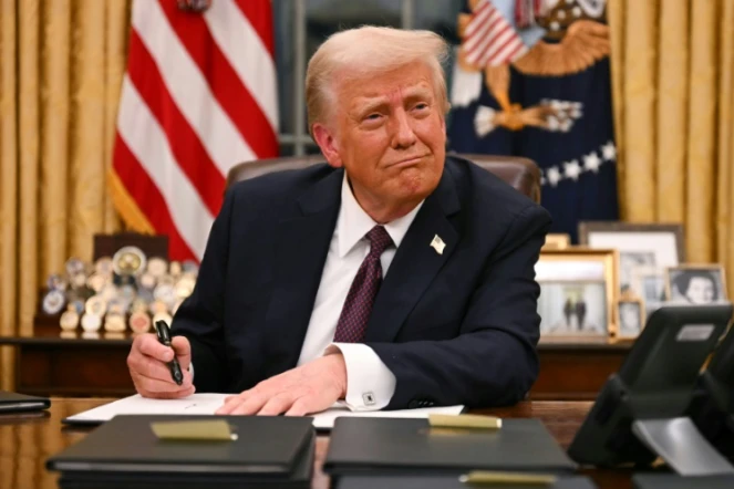 Le président américain Donald Trump signe des décrets dans le Bureau ovale de la Maison Blanche, le 20 janvier 2025 à Washington