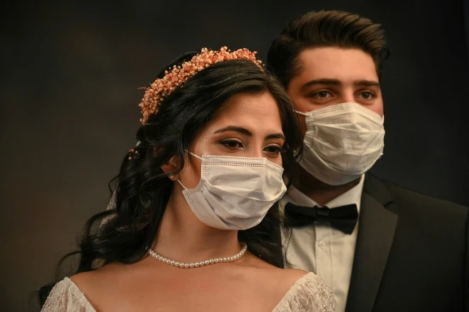 La Turque de 28 ans Ayse Keles et son mari Alp Colak posent masqués pour leurs photos de mariage le 5 septembre 2020 à Istanbul