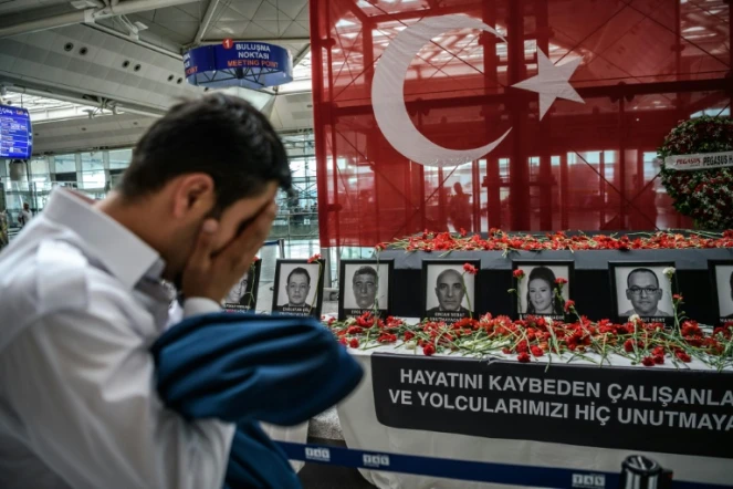 Un employé de l'aéroport se recueille devant un autel en hommage aux victimes des attentats, à l'aéroport Atatürk d'Istanbul