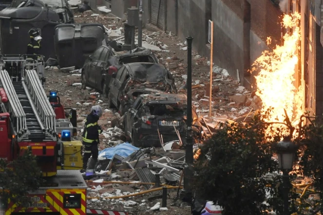 Des pompiers à proximité d'un immeuble détruit par une explosion à Madrid le 20 janvier 2021