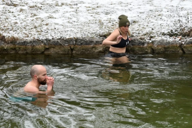 Erina Hey et Franz Mayr se glissent dans les eaux glaciales de la rivière Eisbach dans l'English Garden park de Munich, le 16 janvier 2021