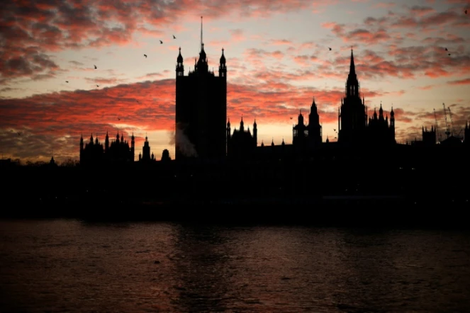 Coucher de soleil derrière le Palais de Westminster, qui abrite la Chambre des Communes où se réunit le Parlement, à Londres le 8 décembre 2020