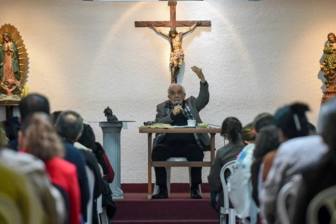 Rafael Arango, président de la Corporation Bethléem Maison Fraternelle, délivre son message assis dos au crucifix face à des dizaines de croyants de tous âges, le 2 septembre 2017 dans le nord-ouest de Bogota