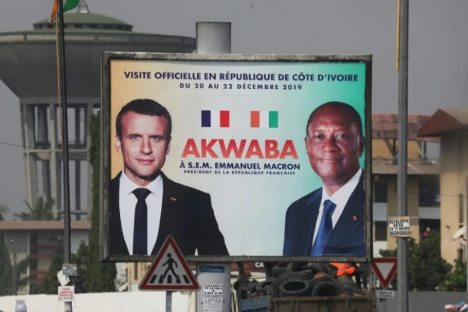 Une affiche montrant Emmanuel Macron (g) et son homologue ivoirien Alassane Ouattara à Abidjan le 19 décembre 2019
