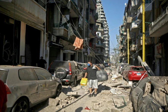 Un homme ramasse ses affaires dans le quartier de Mar Mikhaël le 5 août 2020, le "coeur battant" de Beyrouth dévasté par les explosions de la veille