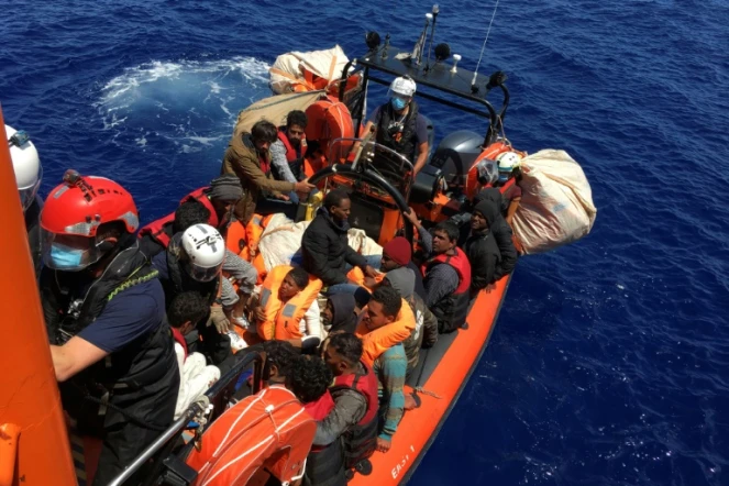Des migrants dans une embarcation en bois sont secours par l'équipe de SOS Méditerranée et recueillis sur le bateau Ocean Viking, au large de l'île de Lampedusa, le 25 juin 2020
