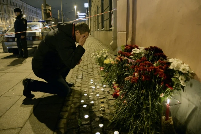 Un homme se recueille après avoir déposé des fleurs en mémoire aux victimes d'un attentat dans le métro, le 3 avril 2017 à Saint-Pétersbourg