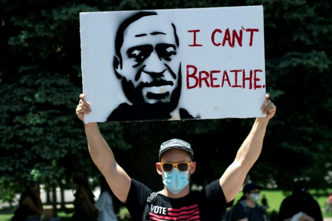 Un manifestant porte une pancarte à l'effigie de George Floyd, le 30 mai 2020 à Denver, dans le Colorado, avec ses derniers mots: "Je ne peux pas respirer"
