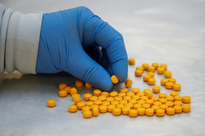 Un agent de l'agence américaine de lutte contre la drogue (DEA) examine des médicaments confisqués contenant du fentanyl, le 8 octobre 2019 dans un laboratoire de New York