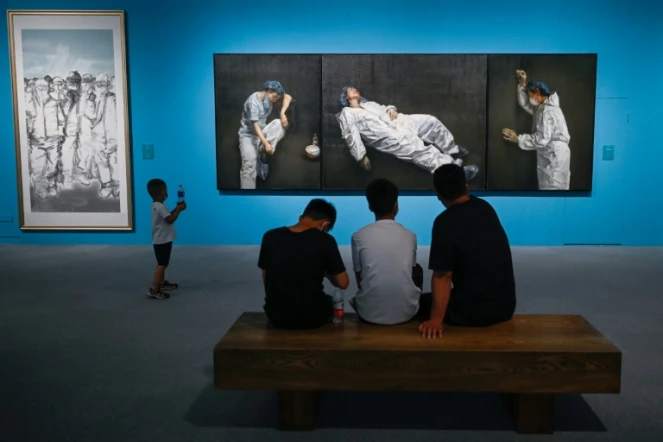 Des visiteurs parcourent l'exposition ?L'union fait la force" sur le combat contre le Covid-19 qui présente notamment un tableau de l'artiste Pang Maokun, au musée national de Chine à Pékin le 5 août 2020