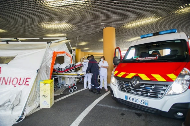 Des pompiers transportent un patient atteint du Covid-19 sur une civière à l'intérieur d'une tente de triage à l'extérieur de l'hôpital universitaire Pierre Zobda-Quitman University hospital (CHU) à  Fort-de-France le 30 juillet 2021
