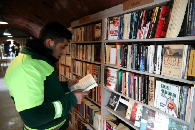 Un homme lit un livre dans une bibliothèque créée par des éboueurs d'Ankara, le 9 janvier 2018
