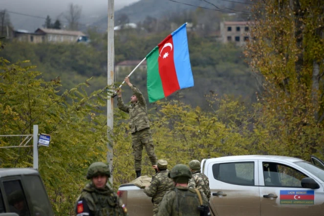 Un soldat azerbaïdjanais hisse le drapeau de son pays sur un réverbère à Latchin le 1er décembre 2020