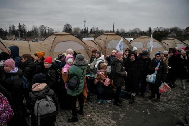 Des réfugiés attendent d'être transportés après avoir traversé la frontière ukraino-polonaise au poste frontière de Medyka, dans le sud-est de la Pologne, le 9 mars 2022
