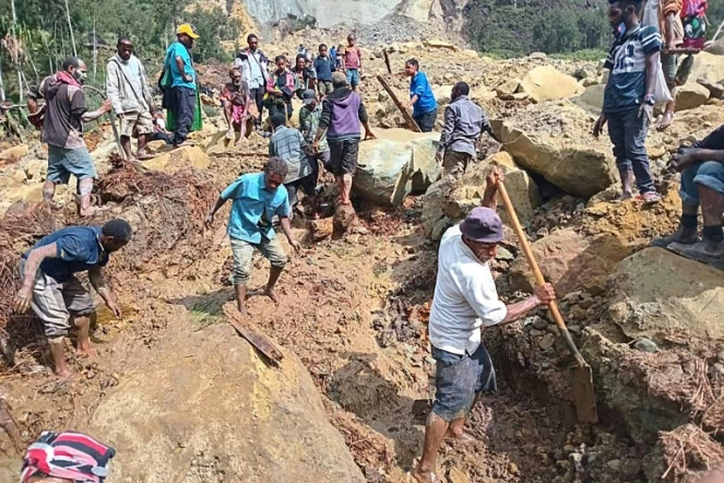 Photo prise et diffusée par l'Organisation internationale pour les migrations le 26 mai 2024 de personnes en train de creuser dans le village de Yambali, situé dans la région de la Papouasie-Nouvelle-Guinée, frappée par un glissement de terrain