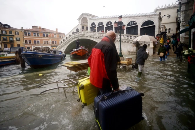 Un homme et ses valises près du po,t Rialto le 15 novembre 2019 à Venise