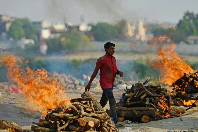Un homme marche entre les bûchers d'un crématorium à Allahabad, en Inde, le 27 avril 2021