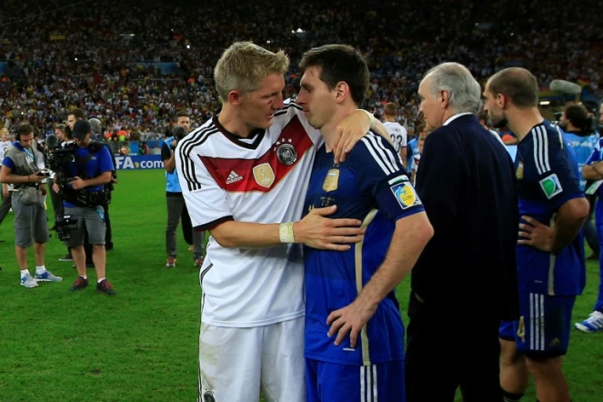 L'attaquant vedette de l'Argentine Lionel Messi consolé par le milieu de terrain allemand Bastian Schweinsteiger après la victoire de l'Allemagne en finale du Mondial, le 13 juin 2014 à Rio