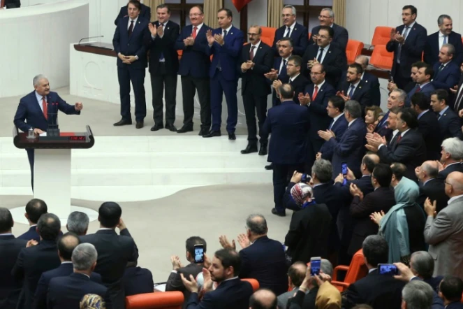 Le Premier ministre turc Binali Yildirim (g) est applaudi au Parlement, le 21 janvier 2017 à Ankara