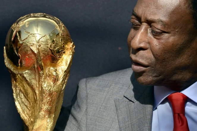 La légende brésilienne du football Pelé regarde le trophée de la Coupe du monde de la FIFA lors d'un événement à Paris, le 9 mars 2014