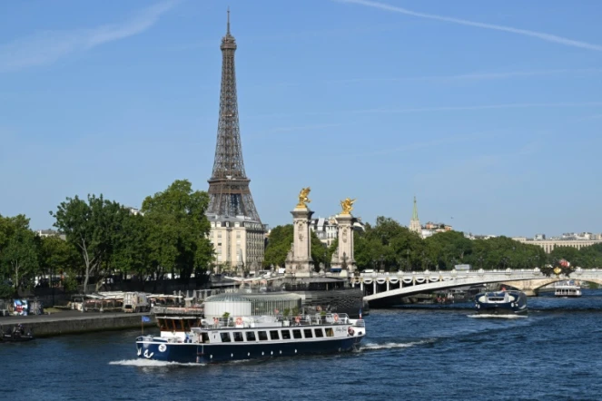 Une péniche passe devant la Tour Eiffel, sur la Seine, le 17 juillet 2023, lors d'un test des "manœuvres", "distances", "durée" et "capture vidéo" de la future cérémonie d'ouverture des JO de Paris en 2024
