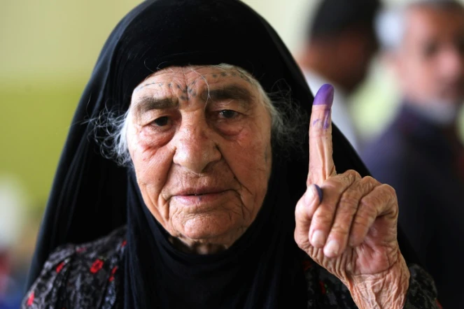 Une Irakienne montre son doigt avec de l'encre dessus --signe qu'elle a voté-- dans la ville de Mossoul, dans le nord de l'Irak, le 12 mai 2018 lors des élections législatives