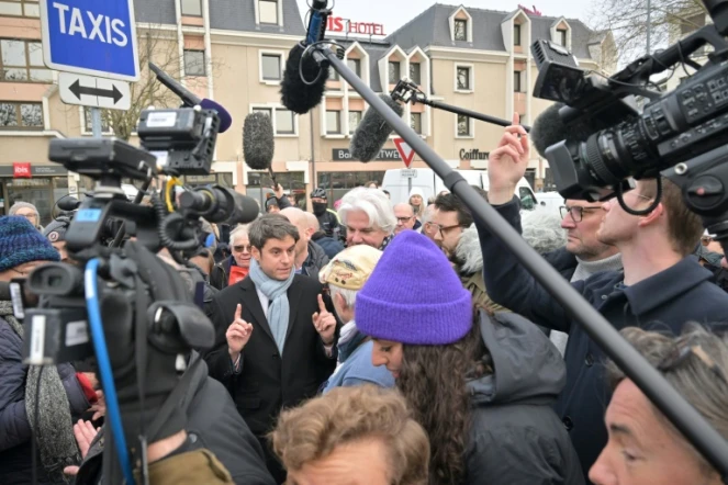 Le Premier ministre Gabriel Attal (c) parle avec des habitants sur le marché de Caen, le 14 janvier 2024 dans le Calvados
