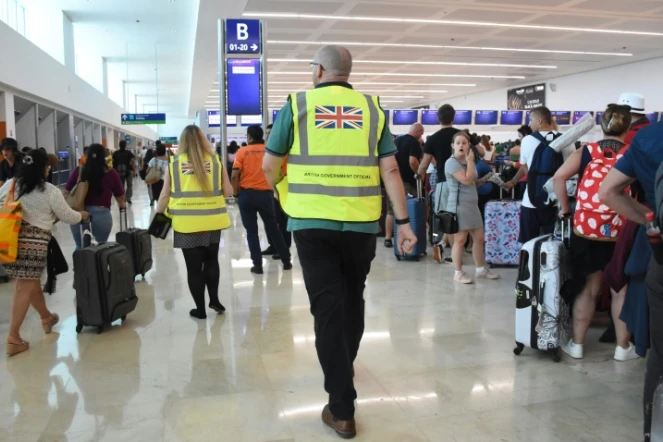 Des responsables britanniques apportent leur aide à des clients de Thomas Cook à l'aéroport de Cancun, au Mexique, le 23 septembre 2019