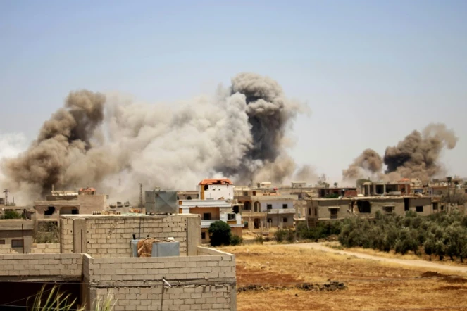 De la fumée au-dessus de la ville de Deraa pendant des frappes aériennes des forces armées syriennes, le 24 juin 2018