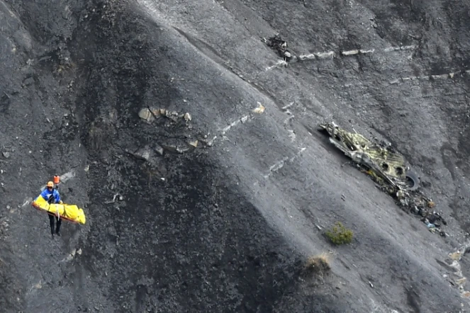 Un enquêteur transporté par un hélicoptéère de la gendarmerie française survole des débris de l'Airbus A320 de la compagnie allemande Germanwings sur le site du crash, le 26 mars 2015 près de Seyne-les-Alpes en France