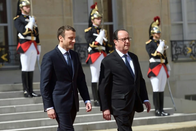 Le nouvellement élu président Emmanuel Macron et son prédécesseur François Hollande lors de la passation de pouvoir à l'Elysée, le 14 mai 2017 à Paris