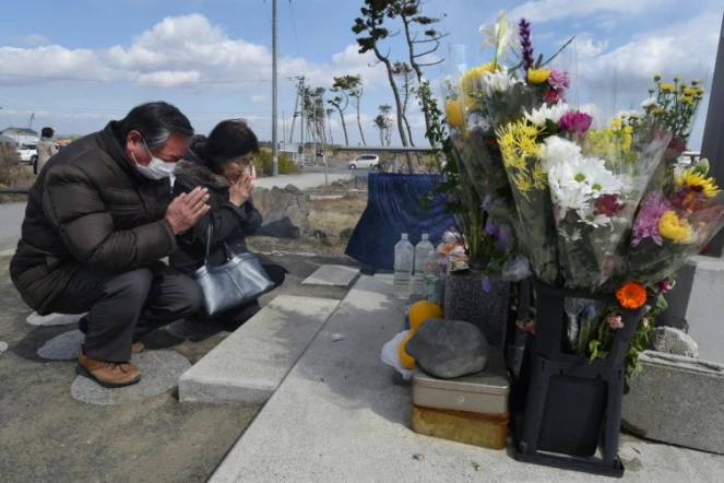 Des personnes prient pour les victimes du séisme, du tsunami et de l'accident nucléaire de 2011, le 11 mars 2016 à Sendai, au Japon