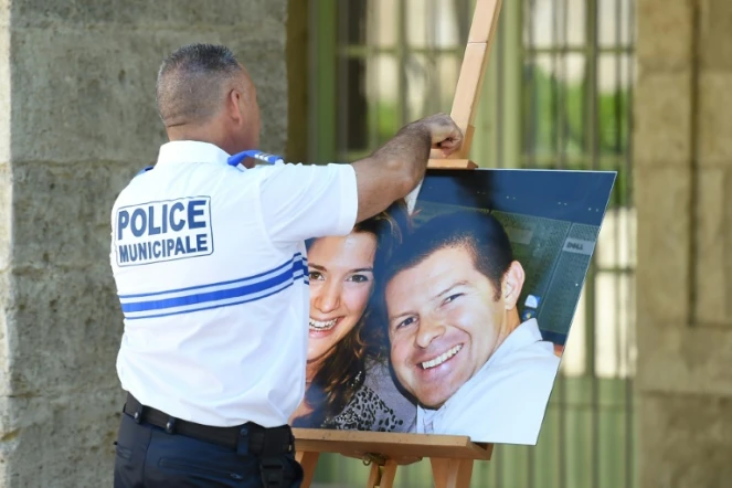 Un policier décroche la photographie de deux policiers Jean-Baptiste Salvaing et Jessica Schneider le 20 juin 2016 à Pézenas