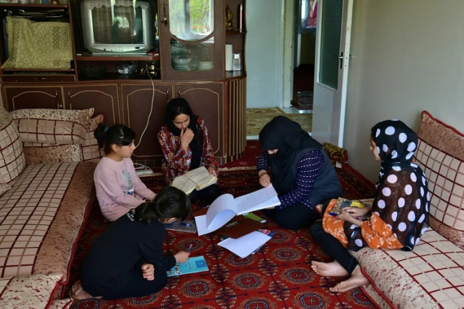 Malahat Haidari(d), sa soeur Adeeba (c) et leurs deux jeunes soeurs étudient chez elles avec leur mère, le 24 mars 2022 à Kaboul, au lendemain de la fermeture par les talibans des écoles secondaires pour les filles