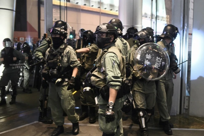 Des policiers sortent du centre commercial Langham Place après y avoir cherché des manifestants, le 26 déceùbre 2019 dans le quartier de Mong Kok, à Hong Kong